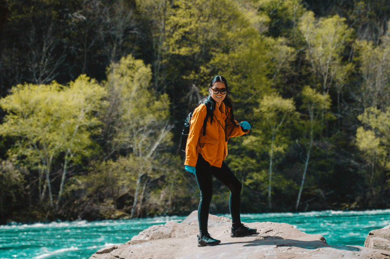 A smiling hiker standing on a river bank in Niagara, Ontario. This could represent self fulfillment.  Learn more about how you can find self fulfillment in Ontario, CA by searching for an Ontario therapist. They can assist you in creating a fulfillment in life in Ontario, CA via online therapy in Ontario and other services.