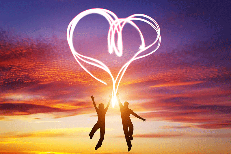 A silhouette of a couple jumping in the air and touching a swirling light in the shape of a heart. This could represent having a fulfilling relationship in Ontario. CA. Learn more about the signs of feeling fulfilled in a relationship Toronto, CA today. 